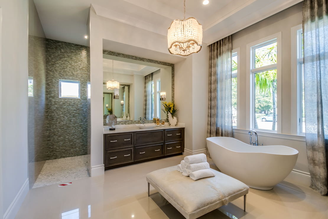 Luxury bathroom with a large mirror and natural light next to the bathtub