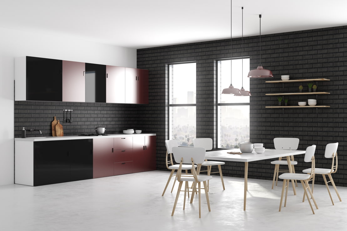 Microcement flooring in a kitchen with exposed brick walls and furniture combining black and red