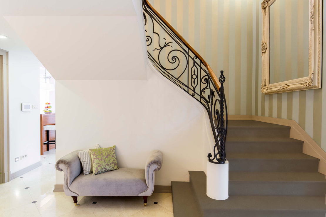 Microcement staircase in a classic style house with wallpaper on the walls.