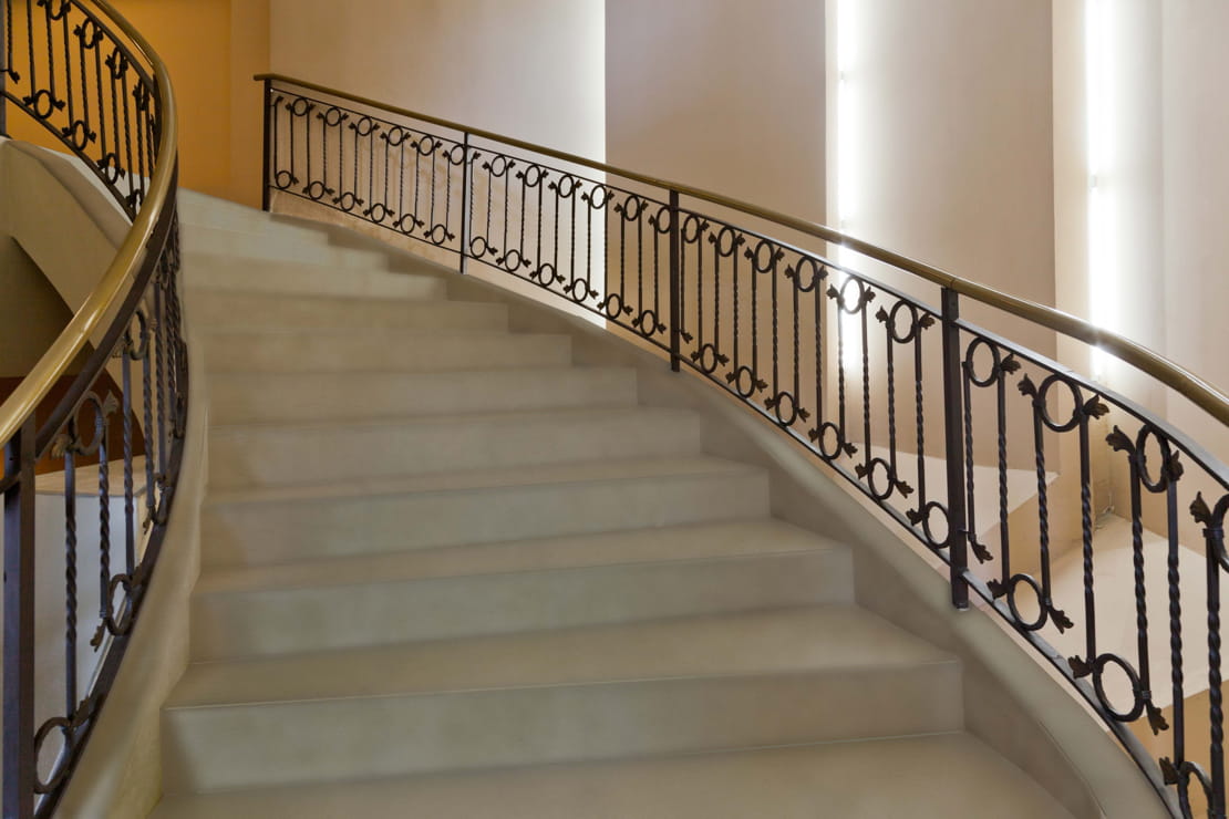 Microcement staircase with wooden handrail on both sides