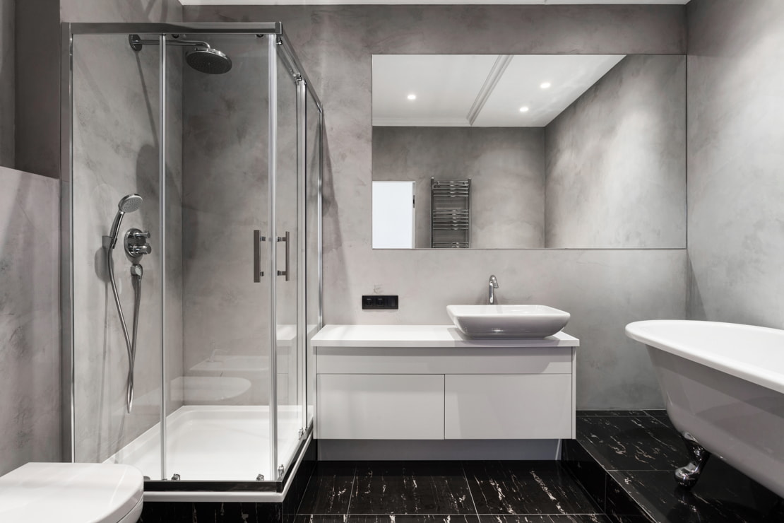 MiMicrocement on the walls of a double-height bathroom with a bathtub.