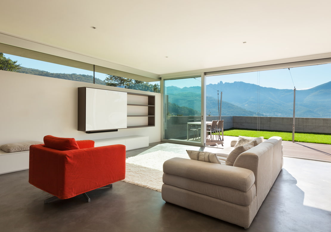 Luxury living room with microcement on the floor overlooking a garden terrace